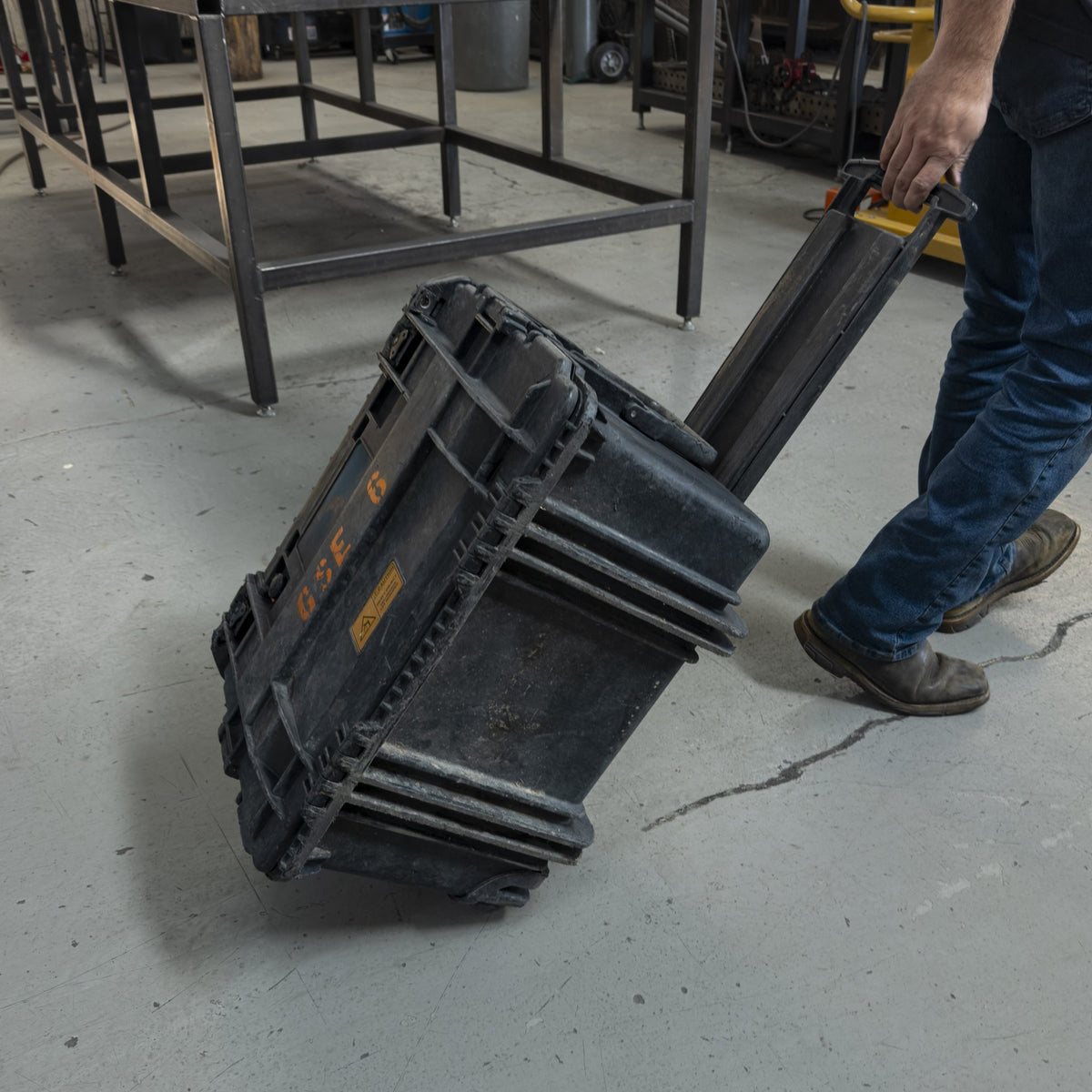 Military tool kit case being rolled by its pull handle