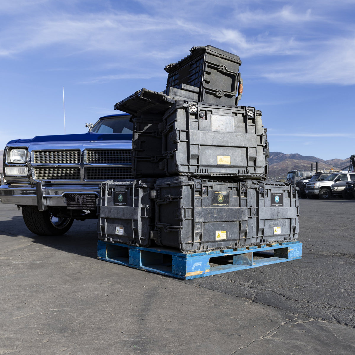 Stack of military tool kit cases next to a Ram Charger