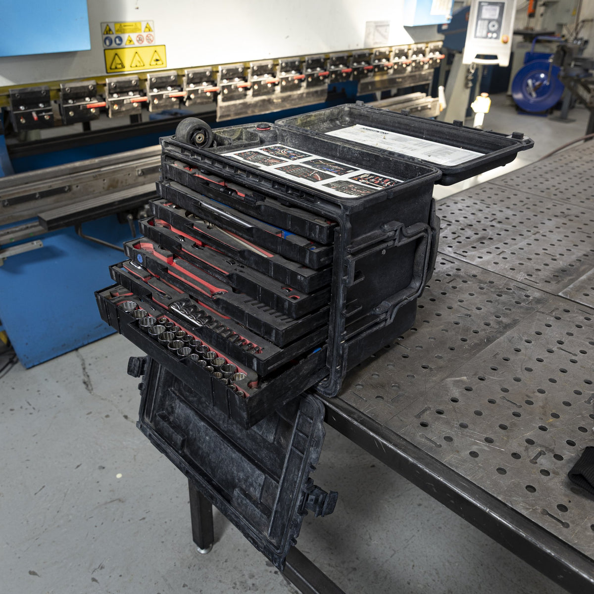 Military tool kit case with drawers open on a shop table